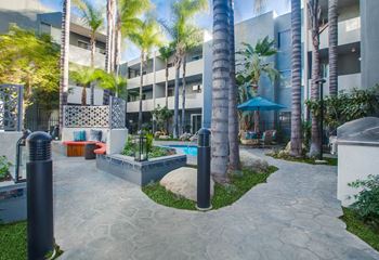 A courtyard with a pool surrounded by palm trees.